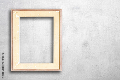 Old picture frame on white cement wall. © Theeradech Sanin