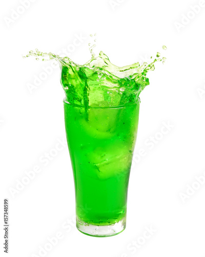 Green soft drink splashing out of glass isolated on white background.