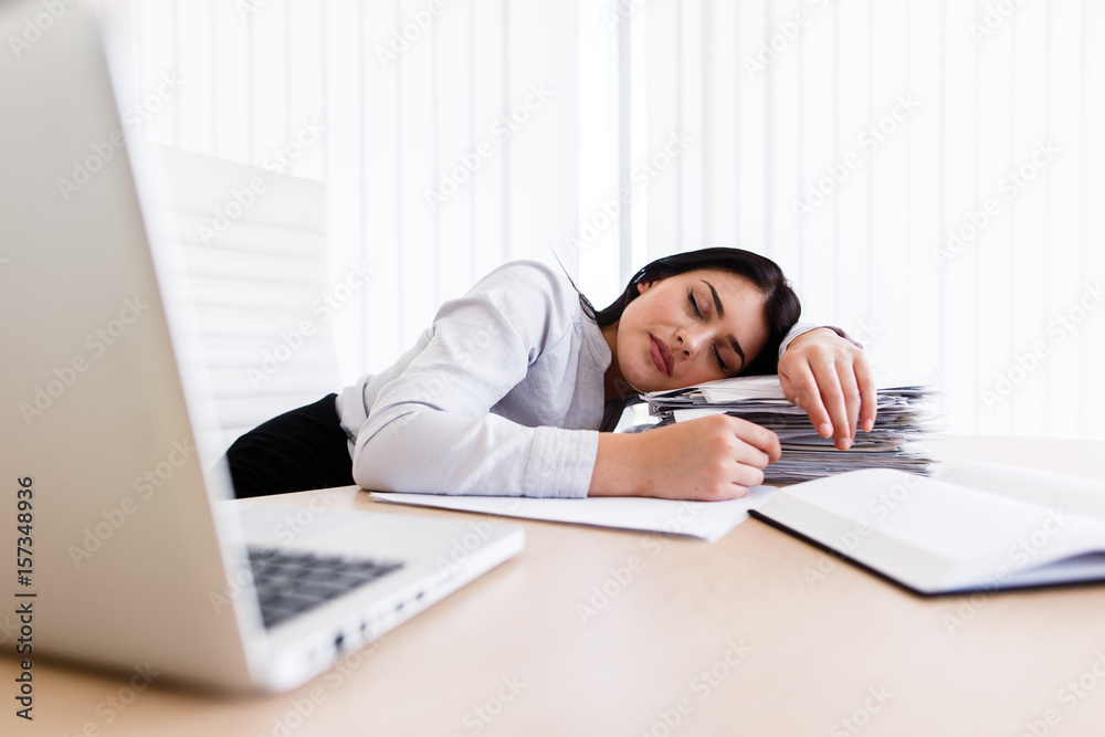 Tired woman sleeping on her work desk during the working time Tired woman sleeping on her work desk during the working time