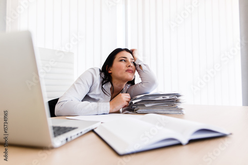 Woman at her work desk dreaming about something beautiful
