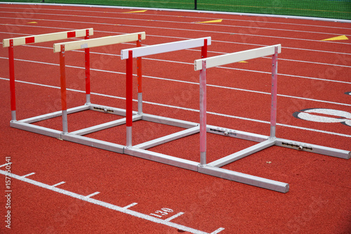 hurdles in a row on red sport field