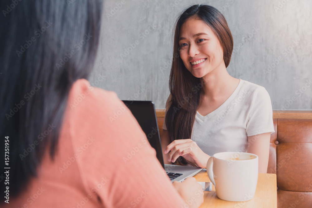 Young beautiful asian woman working and talking with laptop in coffee shop background Young beautiful asian woman working and talking with laptop in coffee shop background
