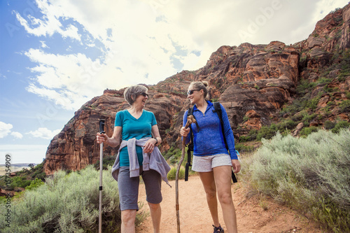 Women hiking together in a beautiful red rock canyon