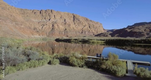 Colorado River with desert mountain.  Aerial flying over trees to reveal the river.