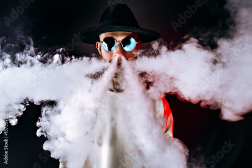 Stylish man puffing vapor photo