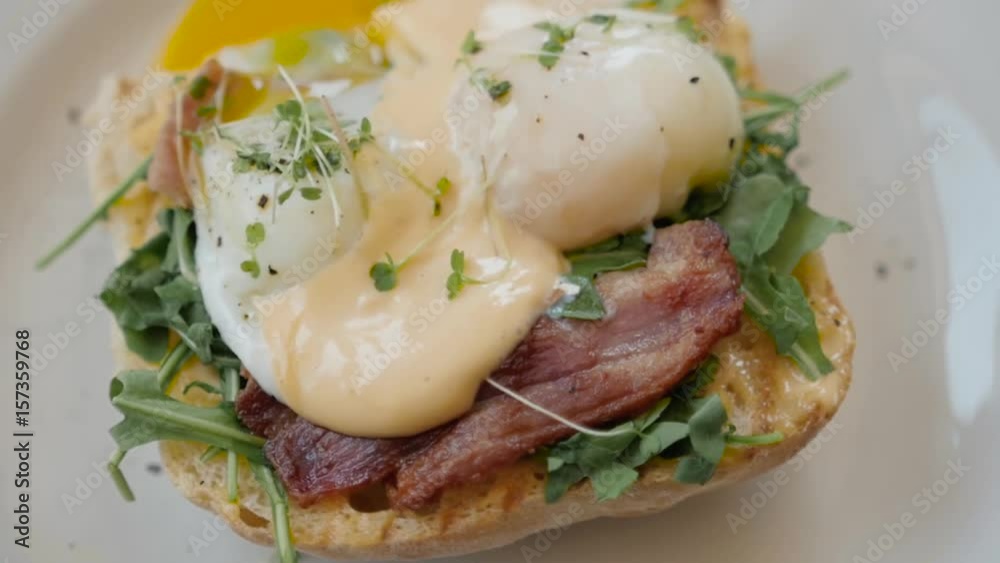 Eggs Benedict with bread and tomato on a plate with becon morning sandwich Eggs Benedict with bread and tomato on a plate with becon morning sandwich