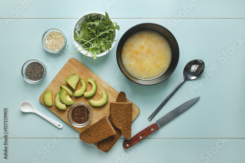 Dinner table. Vegetarian soup with mushrooms and toast with arugula, avocado, sesame and quino chia photo