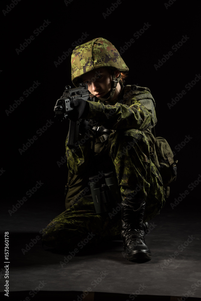 Portrait of armed woman with camouflage. Young female soldier observe with firearm. Child soldier with gun and binoculars in war, black background. Military, army people concept Portrait of armed woman with camouflage. Young female soldier observe with firearm. Child soldier with gun and binoculars in war, black background. Military, army people concept