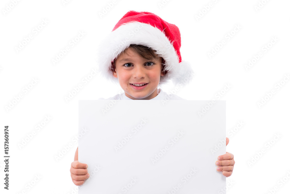 Süsser Junge mit Nikolausmütze, T-Shirt und weißem Schild Süsser Junge mit Nikolausmütze, T-Shirt und weißem Schild