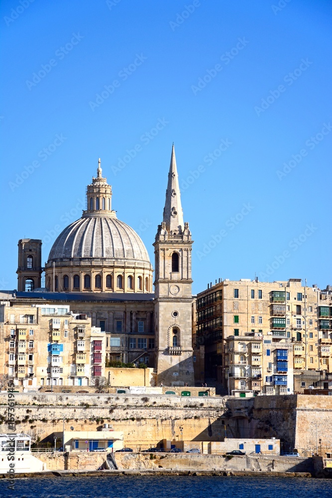 View of St Pauls Anglican Cathedral and the Basilica of Our Lady of Mount Carmel seen from the Grand Harbour, Valletta, Malta.