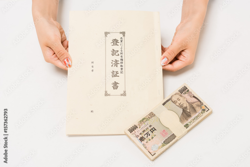 手付金の百万を渡し登記簿謄本 権利書を受取る日本人の女性 StockFoto Adobe Stock
