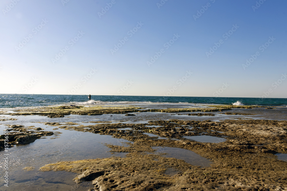 Sea fishing on rocks in tide sea