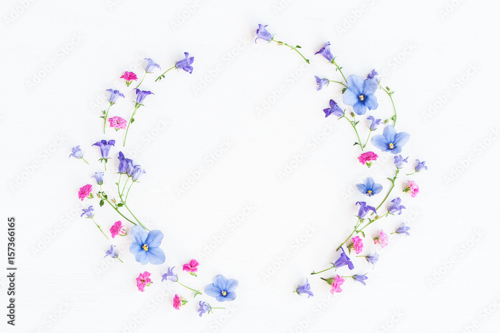 Wreath made of bell flowers, pansy flowers and pink flowers on white background. Flat lay, top view