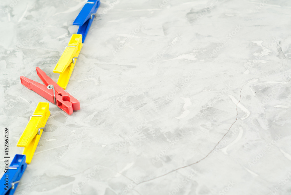Plastic red blue and yellow clothespins on concrete background Plastic red blue and yellow clothespins on concrete background