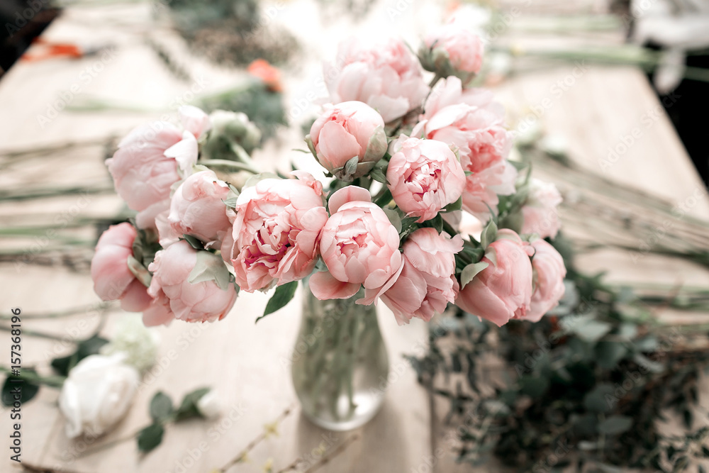 Naklejka Różowe peonie w wazie na drewnianym podłoga i bokeh tle - retro projektująca fotografia. miękka ostrość.