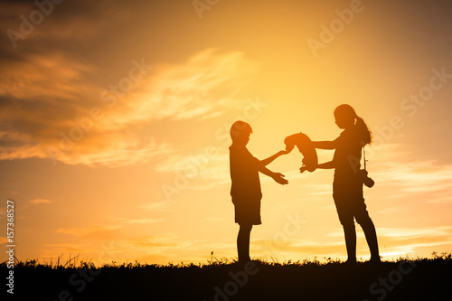 Silhouette mother and child playing with dogs, Concept play with dog.