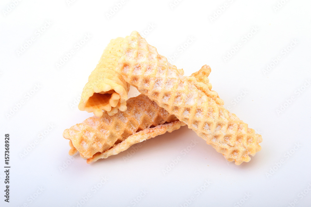 Homemade wafer rolls with powdered sugar isolated on white background