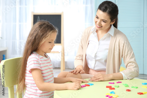 Young woman teacher and little girl on private lesson