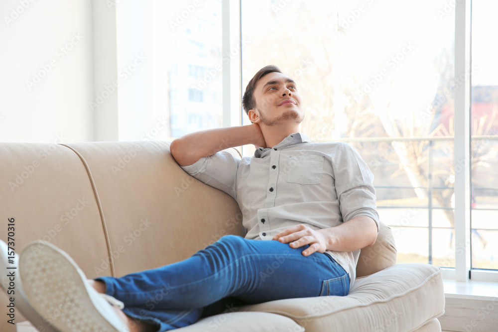 Happy young man resting on sofa Happy young man resting on sofa