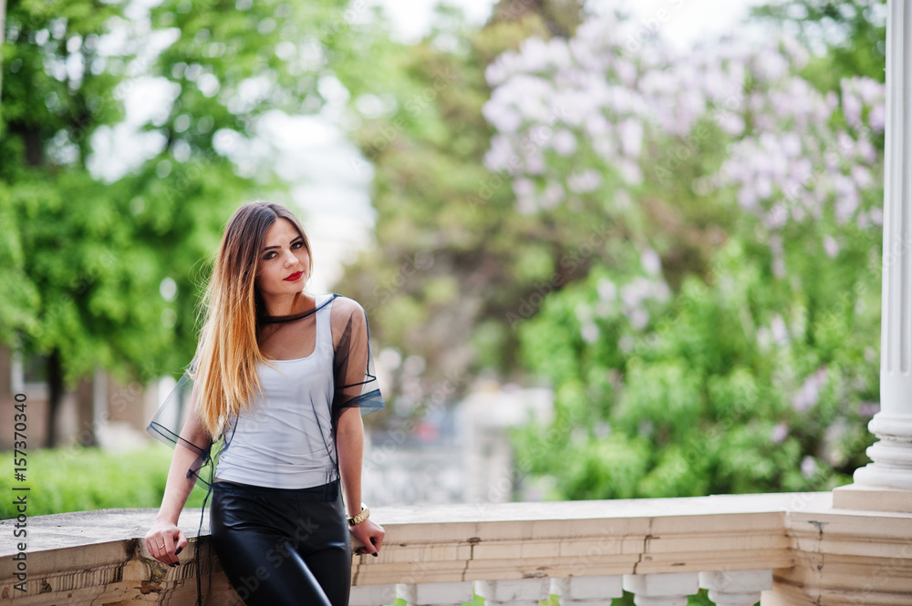 Fashionable woman look at white shirt, black transparent clothes, leather pants, posing at street. Concept of fashion girl. Fashionable woman look at white shirt, black transparent clothes, leather pants, posing at street. Concept of fashion girl.