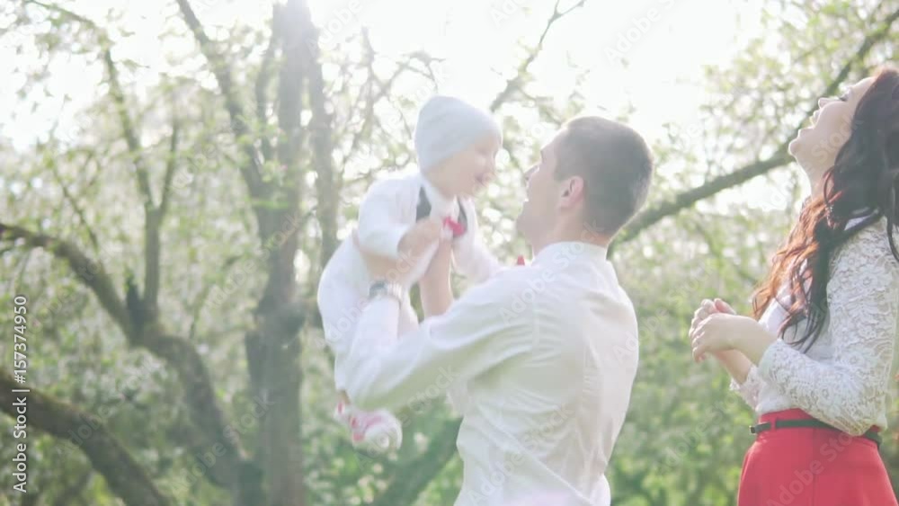 Young Dad tosses the baby in the park Young Dad tosses the baby in the park