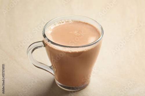 Cup of tasty cocoa drink on light background