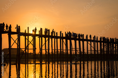 Silhouettes of people on U Bein bridge over the Taungthaman Lake at sunset, in Amarapura, Mandalay, Myanmar