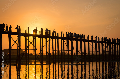 Silhouettes of people on U Bein bridge over the Taungthaman Lake at sunset, in Amarapura, Mandalay, Myanmar photo