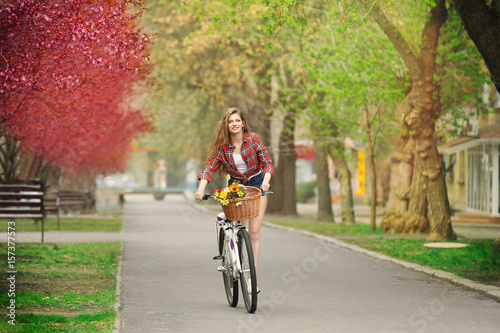 Young smiling girl cycling in park