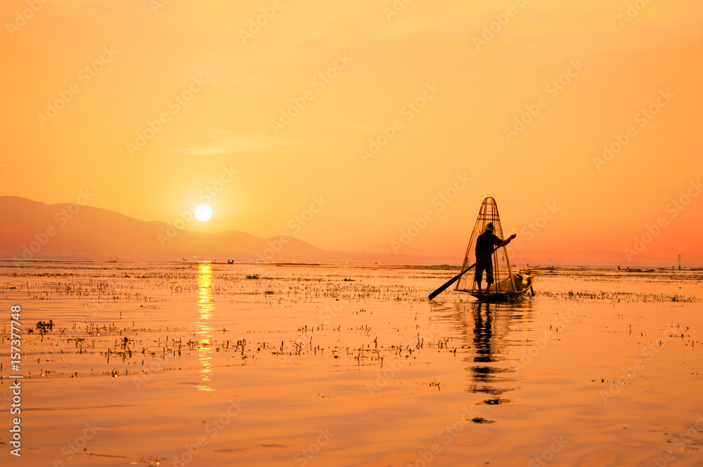 Silhouette of a Burmese fisherman on bamboo boat at sunset. Inle lake, Myanmar (Burma), travel destination