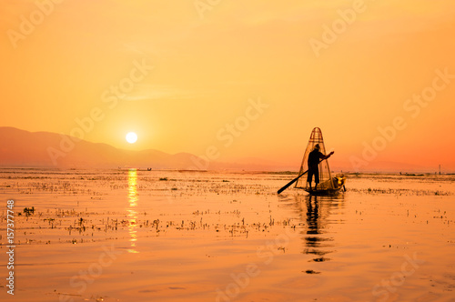 Silhouette of a Burmese fisherman on bamboo boat at sunset. Inle lake, Myanmar (Burma), travel destination