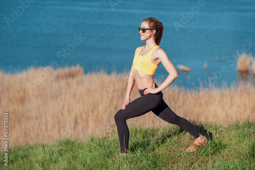 Warming up before jogging. Attractive young woman in sports clothi