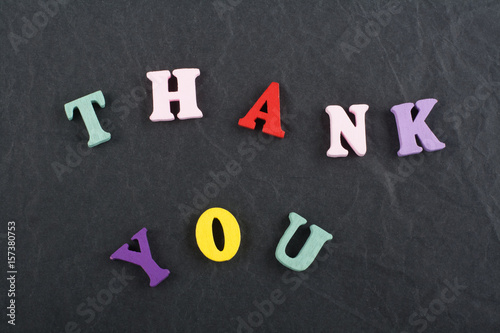 THANK YOU word on black board background composed from colorful abc alphabet block wooden letters, copy space for ad text. Learning english concept.
