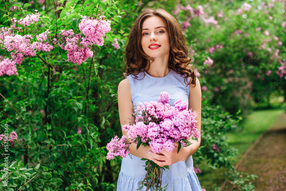 Young girl stand at park background with bouquet of flowers Young girl stand at park background with bouquet of flowers