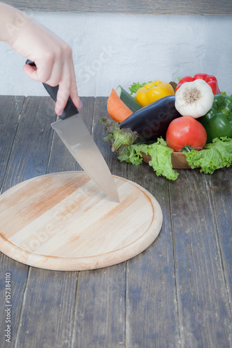 Fresh vegetables on chopping board and dark table. A composition of vegetables in the form of collage. Healthy eating and healthy diet. Zucchini, bell peppers, carrots, cucumber, garlic, tomatoe, eggp photo