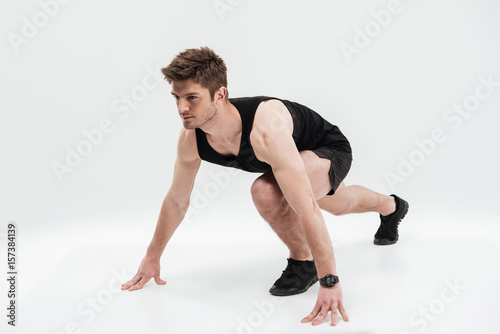 Full length portrait of a concentrated sportsman ready to run
