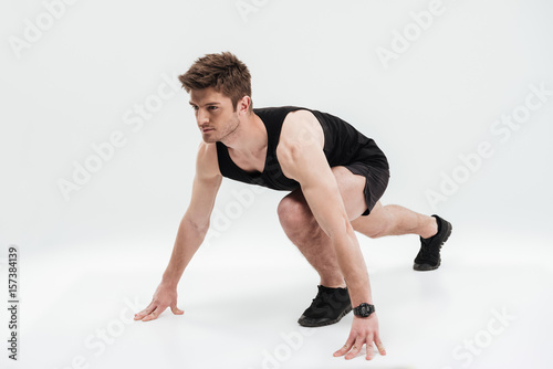 Full length portrait of a concentrated sportsman ready to run © Drobot Dean