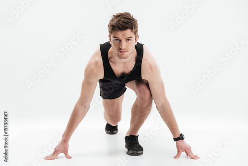 Full length portrait of a concentrated sportsman ready to run © Drobot Dean