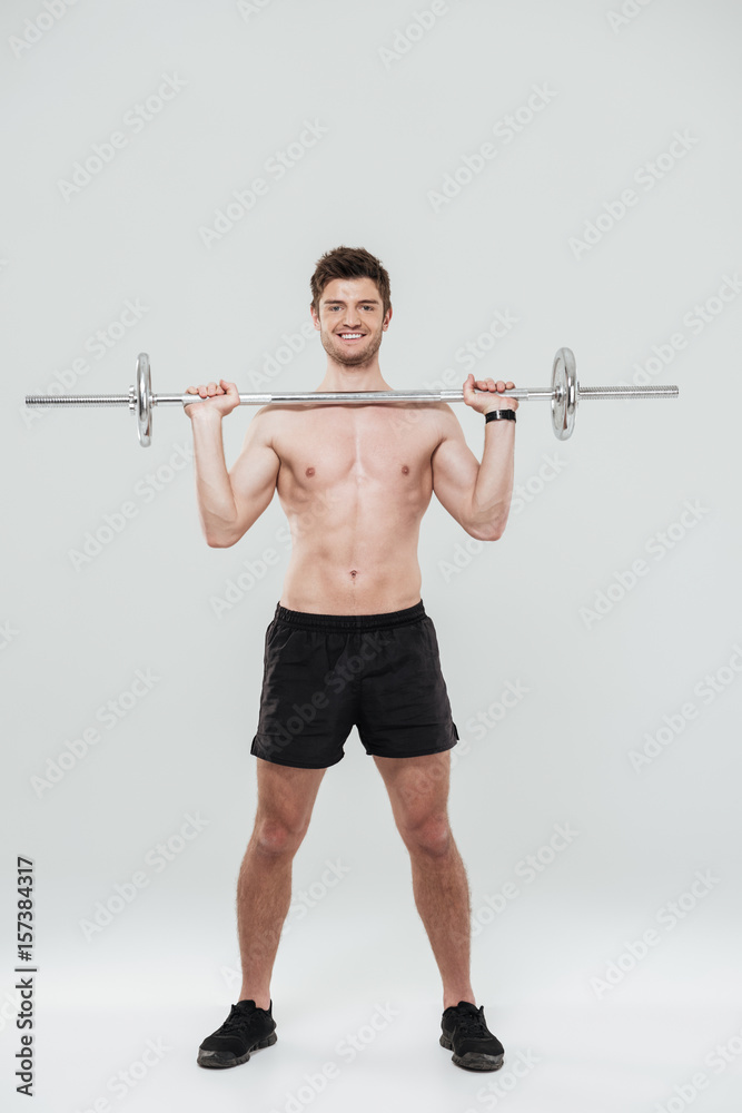 Portrait of a smiling confident sports man holding a barbell Portrait of a smiling confident sports man holding a barbell