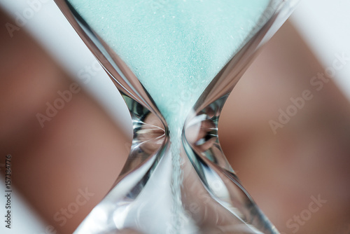 Hand holds hourglass close-up. photo