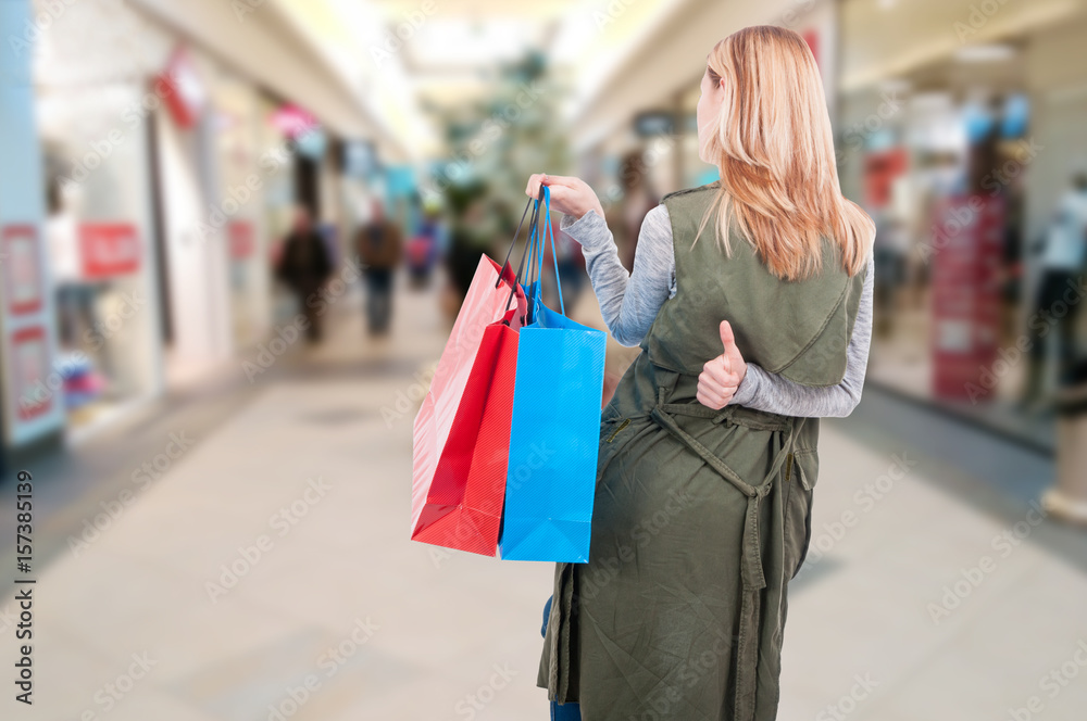 Rear view of woman with shopping bags walking Rear view of woman with shopping bags walking