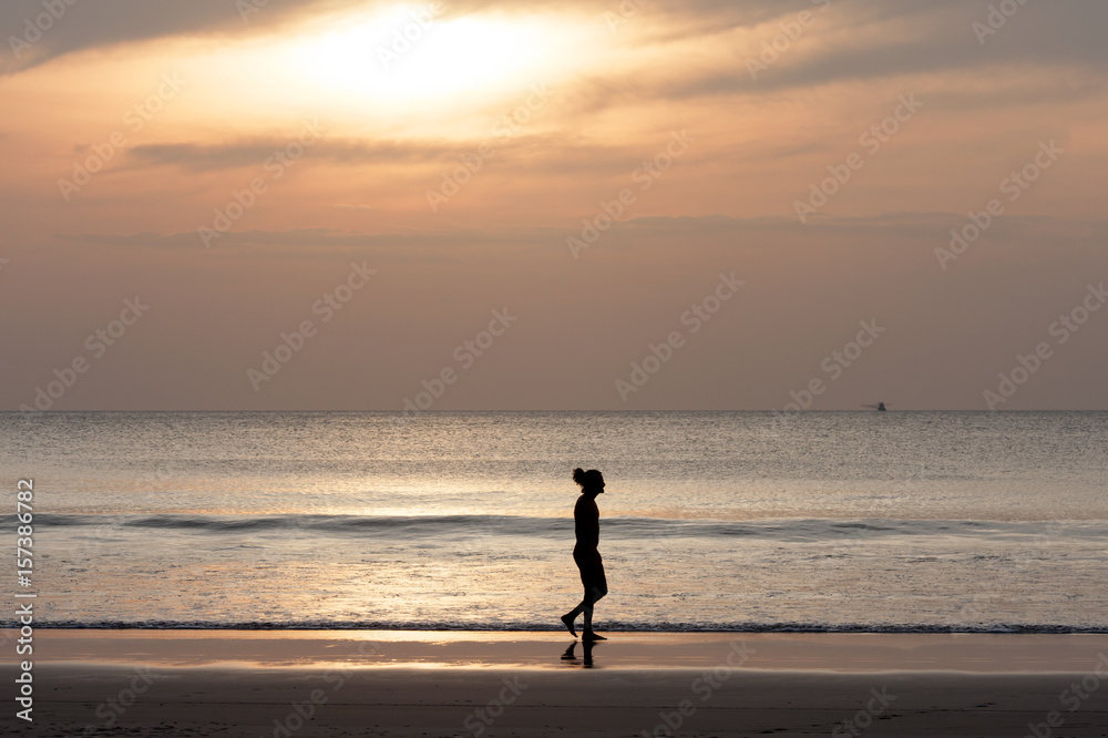 Man walking on the beach at sunset for holiday time, Silhouette sunset
