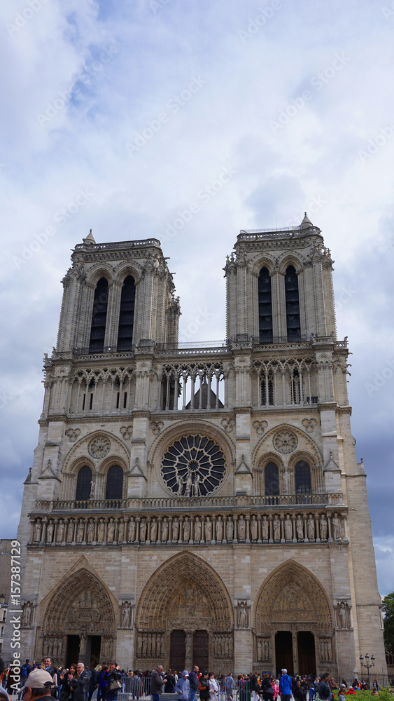 Photo of famous Notre Dame cathedral on a cloudy spring morning, Paris, France