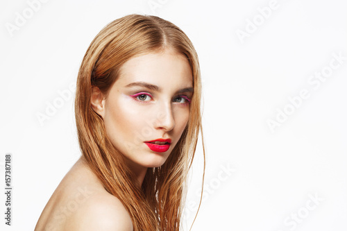Close-up portrait of young beautiful confident girl with bright make up. Looking in camera. White background. Isolated.