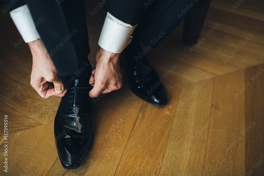 The handsome groom wears wedding shoes