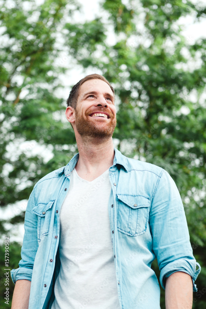 Casual guy with a denim shirt in a park Casual guy with a denim shirt in a park