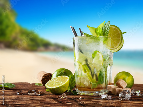 Fresh mojito drinks placed on wooden planks, blur beach on background