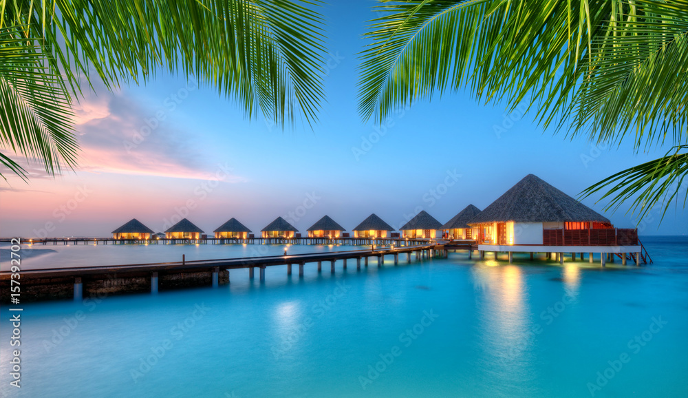 Water villas on Maldives resort island in sunset