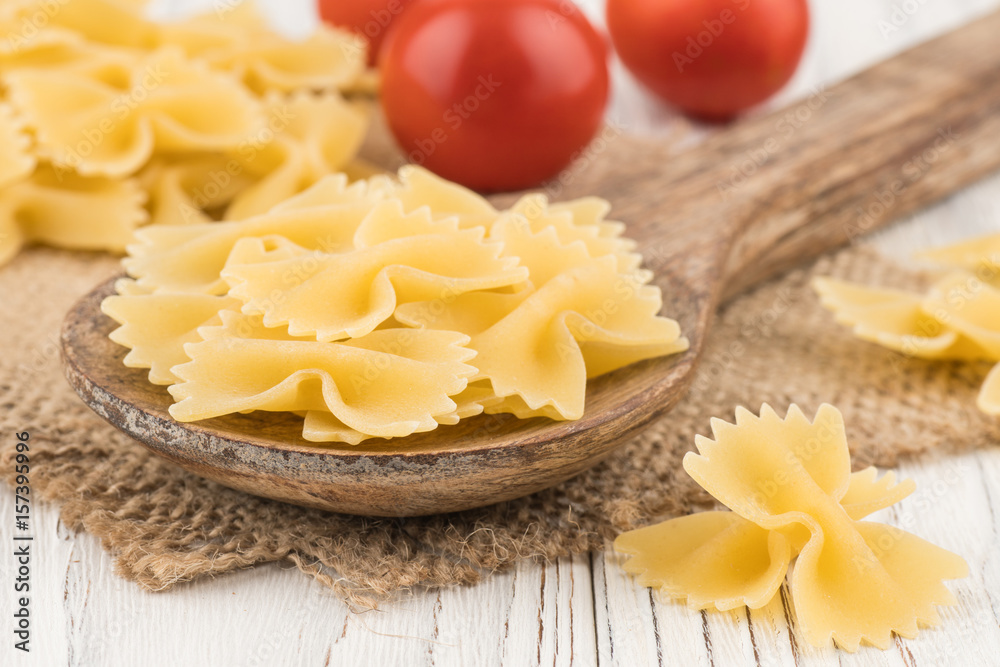 Pasta in a wooden spoon and an old white wooden table. Pasta in a wooden spoon and an old white wooden table.