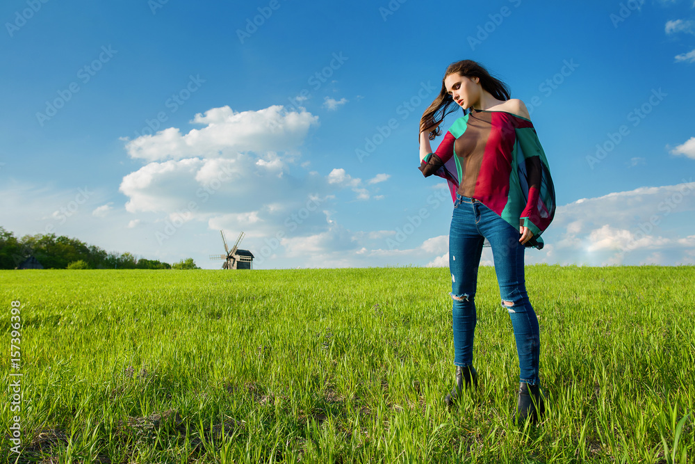 Young beautiful girl with long dark hair in green field in outdoor ethnic village Pirogovo in Kiev Ukraine Young beautiful girl with long dark hair in green field in outdoor ethnic village Pirogovo in Kiev Ukraine